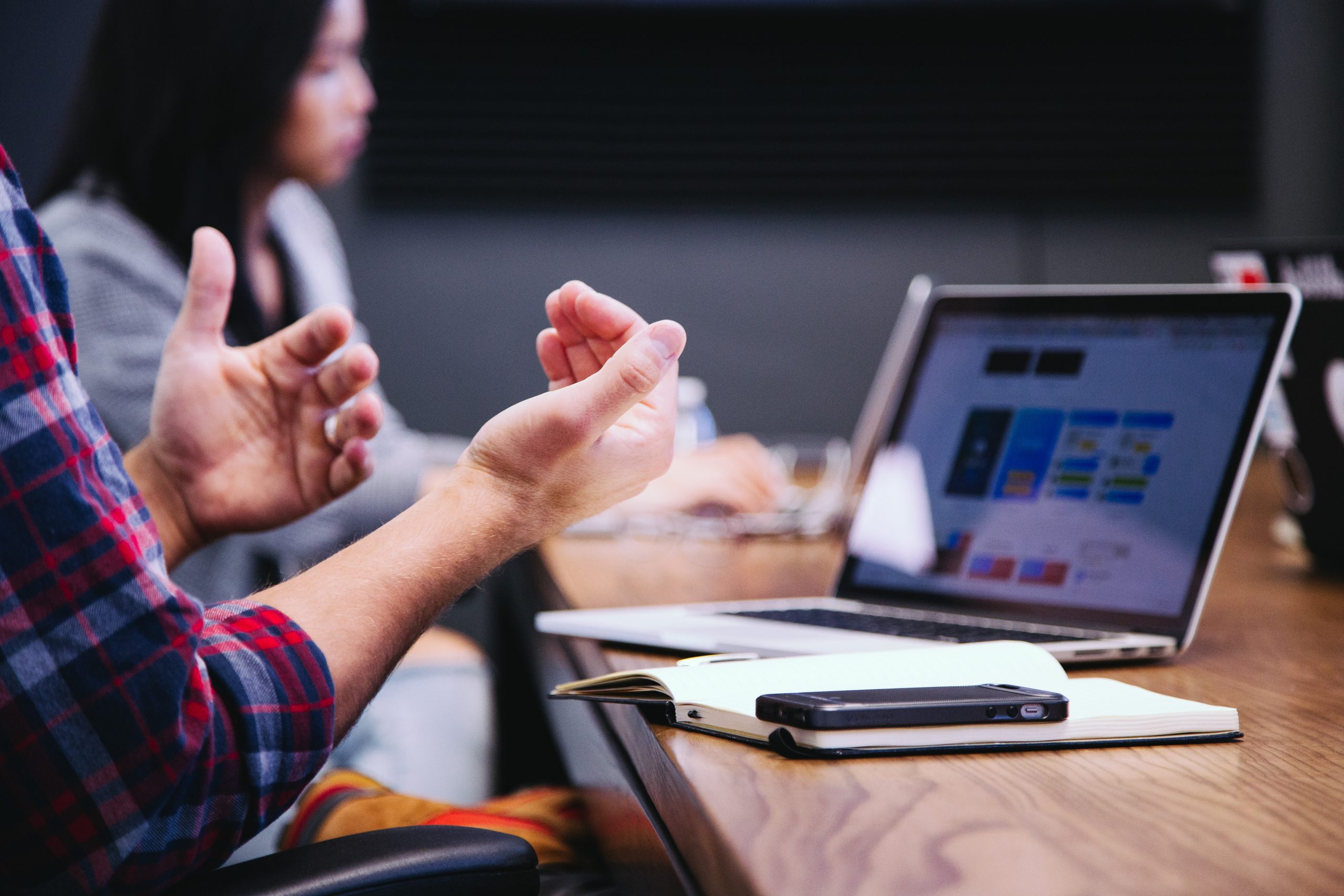 A pair of hands are shown in front of an open laptop