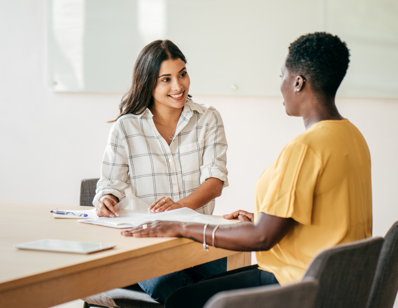 Two women sit at a table talking